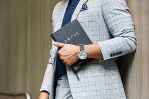 Arcis Man holding journal in a suit and timepiece